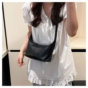 Detail view of large black crossbody moon bag with minimalist vertical stitching detail