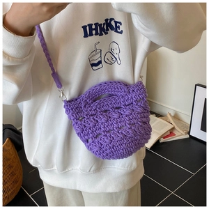 Detail of the purple hand-woven bucket bag showing crochet texture and silver carabiner