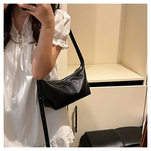 Detail view of the black leather hobo bag with adjustable strap shown in a mirror selfie