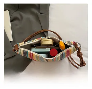Detail of the multi-colored striped straw bag interior with zipper and inner pocket