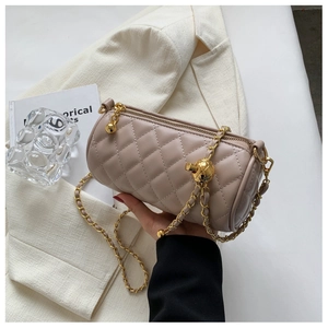Détails du sac cylindre matelassé avec chaîne dorée et charm sphérique métallique