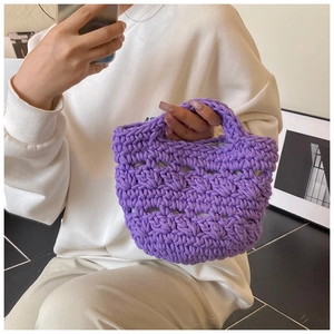 Detail of purple hand-knitted bucket bag with intricate woven texture and soft handle