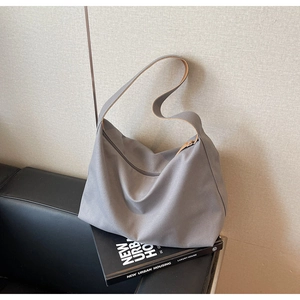 Dettaglio della borsa tote in tela grigio scuro con cerniera superiore e tracolla larga