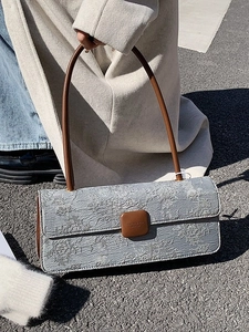 Sac baguette chic en jacquard gris avec lanières en cuir marron et texture gaufrée