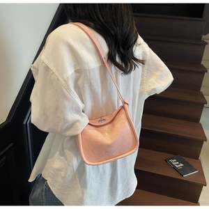 Detail of light pink glossy wrinkled crossbody bag with a silver metal twist lock