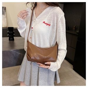Detail of a brown matte leather crescent bag with fine stitching for daily commute