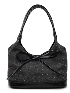 Denim tote bag with large black leather bow and white polka dots on a white background