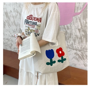 Detail of floral tulip patches on off-white canvas tote bag for casual everyday style
