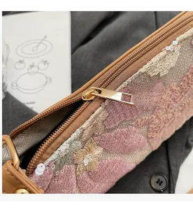 Detail of colorful sequin embroidery and smooth gold metal zipper on a retro handbag