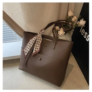 Close-up of dark brown lychee leather tote bag with magnetic pocket and checkered silk scarf
