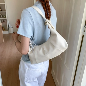Detail of hobo bag in cream pebbled leather with a stylish silver butterfly charm