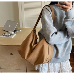 Borsa tote in tela marrone a forma di mezzaluna in un ambiente d ufficio moderno