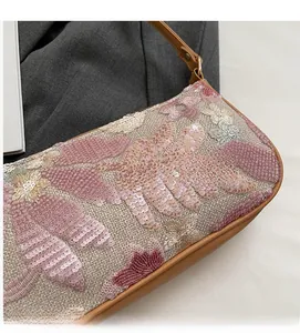 Close-up of sequin floral embroidery and linen texture on vintage style shoulder bag