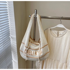 Detailed knit texture and jacquard lettering on a casual beige woven shoulder bag