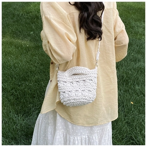 Macro shot of white handmade crochet hollow texture and woven rope handle on the bucket bag