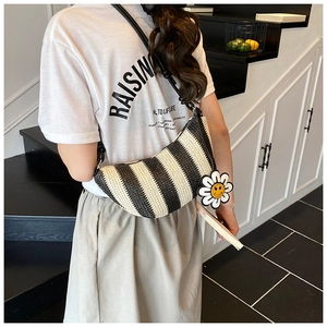 Straw shoulder bag with black and white stripes and a yellow sunflower charm detail
