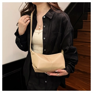 Detail of soft cream-colored hobo bag with premium stitching and adjustable shoulder strap