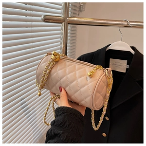 Détail du sac cylindre matelassé abricot clair avec bandoulière chaîne dorée