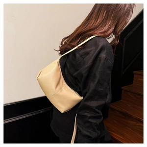Close-up of cream leather shoulder bag featuring side double stitching and matte finish