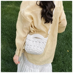Detailed texture of white crochet bucket bag with geometric knit patterns for beach vacations