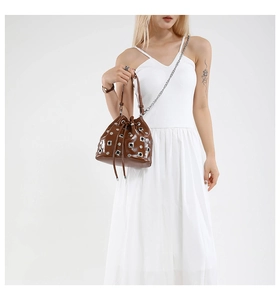 Brown bucket bag featuring shiny leather with silver rivets and metal chain strap