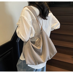 Dettaglio della borsa hobo in tela grande che mostra il drappeggio e la tracolla larga