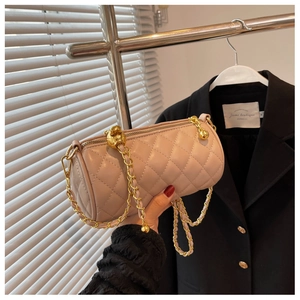 Détail du sac cylindre matelassé rose avec chaîne dorée et boule de réglage en métal