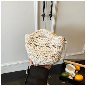 Detail of hand-woven cream crochet bucket bag showing intricate knit texture and strap