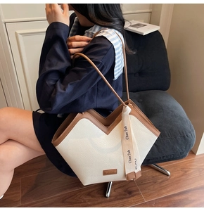 Detail of retro tote bag with cream leather, brown trim and fashion ribbon detail
