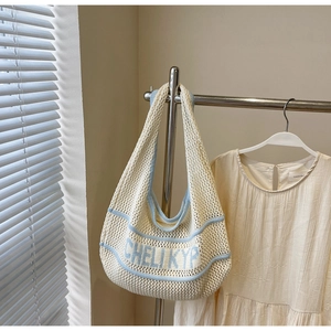 Detailed macro view of the cream and blue woven knit tote bag with mesh hollow structure