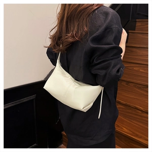 Detail of cream crescent hobo bag with vertical stitching and smooth leather texture