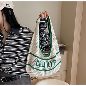 Detail of white and green knitted tote bag with hollow mesh and CELI KYP lettering