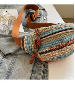 Detail of woven crossbody bag with colorful patterns, wide orange strap and smooth zipper