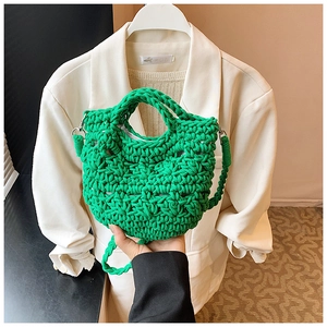 Detail of bright green hand-woven bucket bag with intricate crochet pattern and white lining