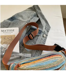 Detail of colorful woven bohemian belt bag with adjustable strap on denim background