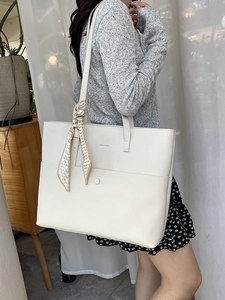 Minimalist beige pebble leather tote bag with silk scarf handle and front pocket