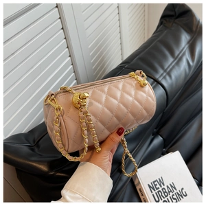 Détail du sac cylindre matelassé rose clair avec chaîne dorée et boule de réglage
