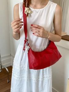 Minimalist red hobo shoulder bag for women with silver heart charm on model