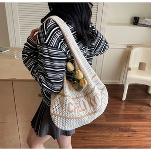 Detail of knit tote bag featuring brown letter embroidery and yellow tulip decoration