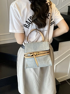 Retro denim handbag with leather trim and crossbody strap shown on model's back