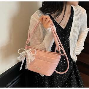 Detail of pink pleated bucket bag with lace pearl bow charm and adjustable knot strap