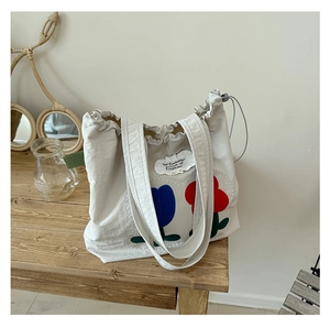 Detail of canvas tote bag with tulip print and be fearless pursuit of happiness slogan