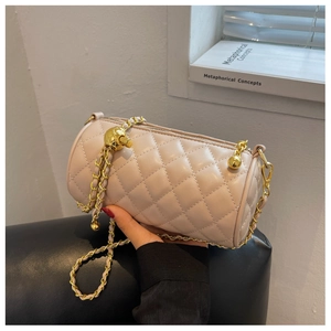 Détail du sac cylindre matelassé avec bandoulière en chaîne dorée et bille ajustable