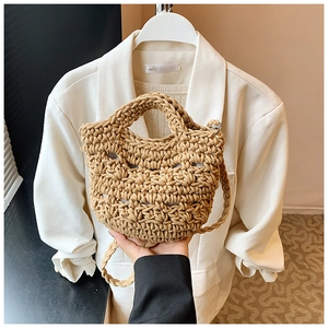 Detailed close-up of khaki hand-woven bucket bag featuring intricate straw texture