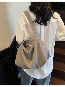 Grande borsa tote in tela taupe con ampia tracolla indossata da una modella