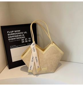 Detailed close-up of a minimalist cream tote bag with textured fabric and fashion ribbon
