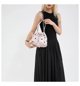 Detail of pink bucket bag with silver studs, drawstring closure and chain strap