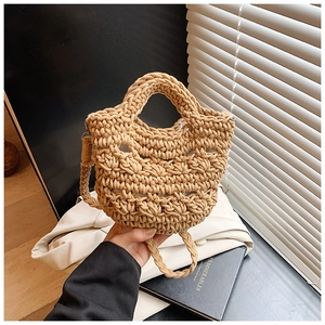 Detail of a beige handmade crochet bucket bag featuring woven textures and strap