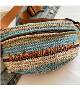 Macro shot of multi-color woven straw bag featuring embroidery and nylon strap