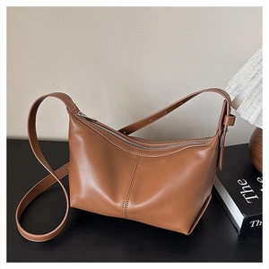 Close-up of vintage brown leather hobo bag showing fine stitching and smooth zipper detail